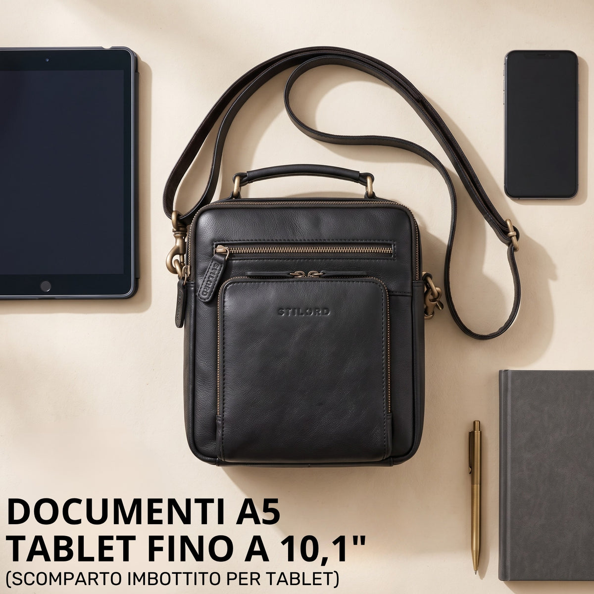 Piccola borsa a tracolla in pelle nera con manico e tracolla regolabile, logo STILORD impresso, vista dall'alto con tablet e smartphone a confronto