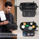 Necessaire Henry in pelle nera, vista dall'alto con scomparti e organizer a sportello, uomo che riempie in bagno