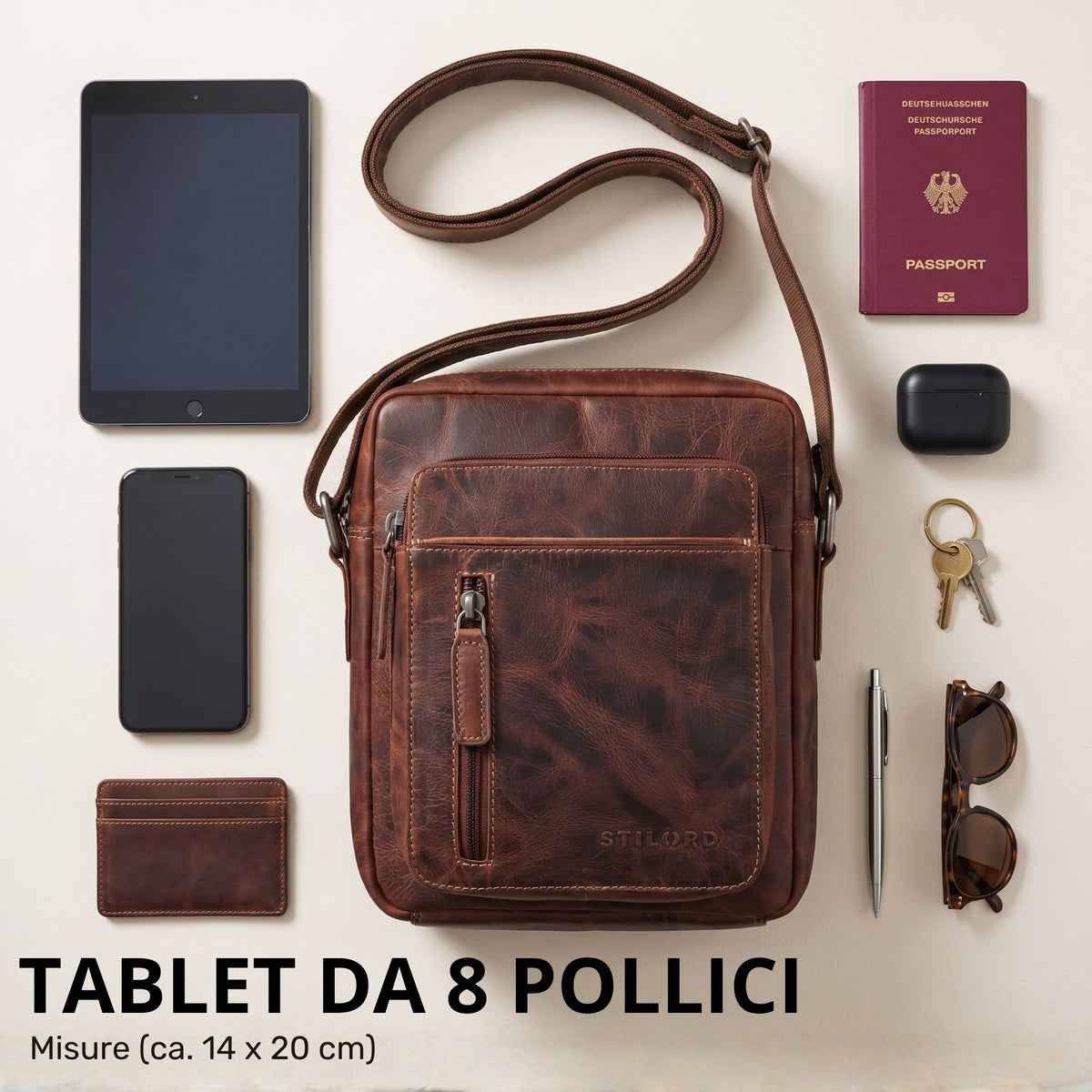 Kleine braune Leder-Umhängetasche mit sichtbarer STILORD-Prägung, Frontalansicht; Riemen aufgerollt, 8-Zoll-Tablet und Accessoires